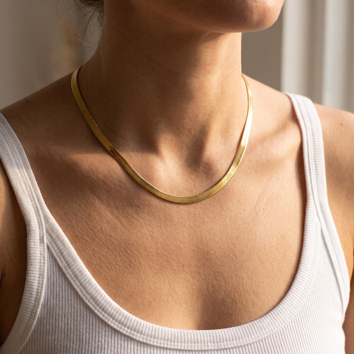 Chelsea Herringbone Necklace in gold worn on the neckline